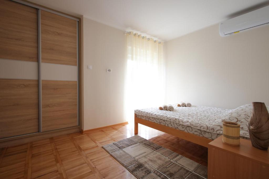 a bedroom with a bed and a large window at Vila Vrnjački Raj in Vrnjačka Banja