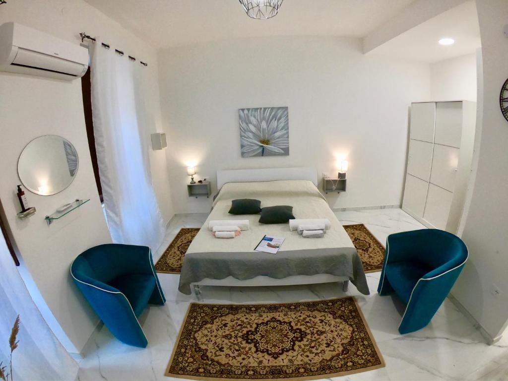 una camera con un letto e due sedie blu di Guest Room historic centre a Iglesias