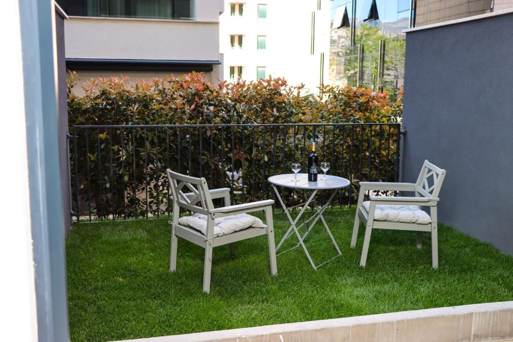 杜布羅夫尼克的住宿－Studio apartmani GITA GARDEN，草坪上一张桌子和两把椅子以及一张桌子