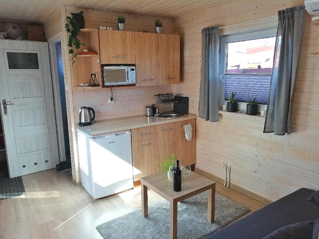 a small kitchen with a white refrigerator and a table at Apartament Antonio 2 Gdańsk in Gdańsk
