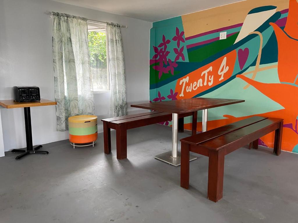 a room with two benches and a large painting at Twenty4 Hostel in Paramaribo