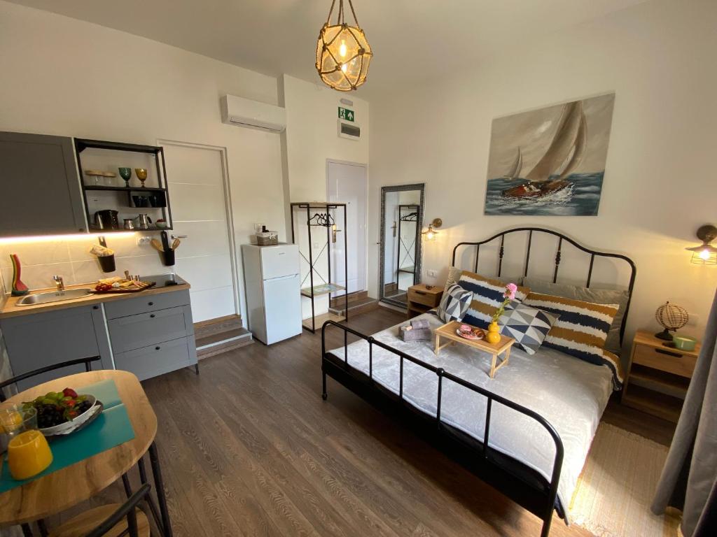 a bedroom with a bed and a kitchen and a table at LukaDoraJana Pula City Center in Pula