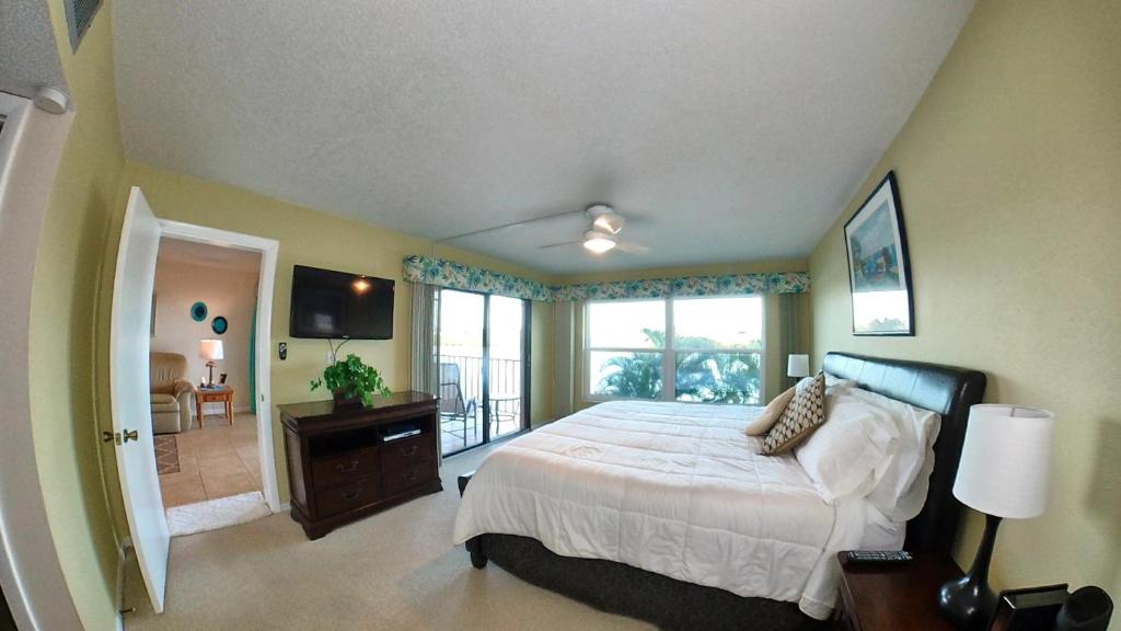 um quarto com uma cama grande e uma varanda em Sea Club Condo #103 em Clearwater Beach