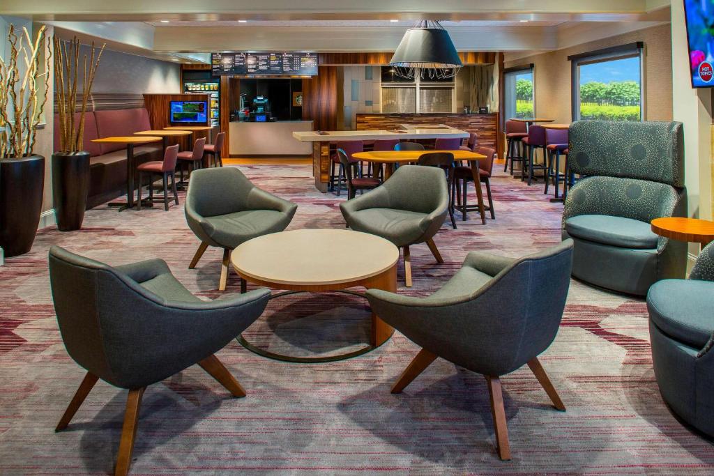a lobby with chairs and tables and a bar at Sonesta Select Boston Lowell Chelmsford in Lowell