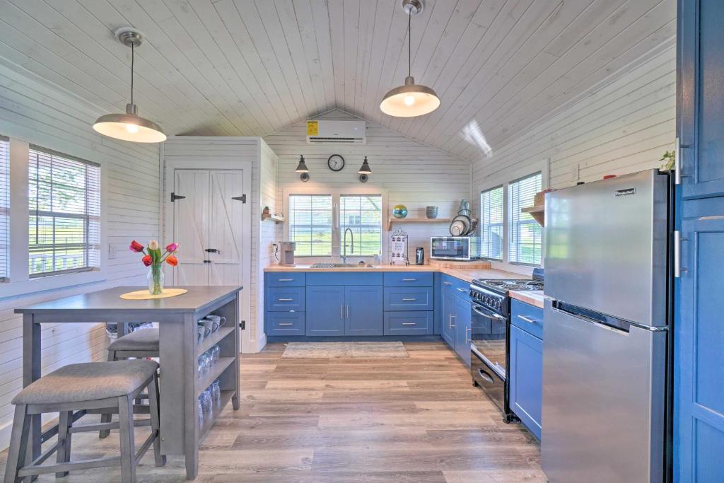 a kitchen with blue cabinets and a table and a refrigerator at Peaceful Country Cottage with Landscape Views in Sweetwater