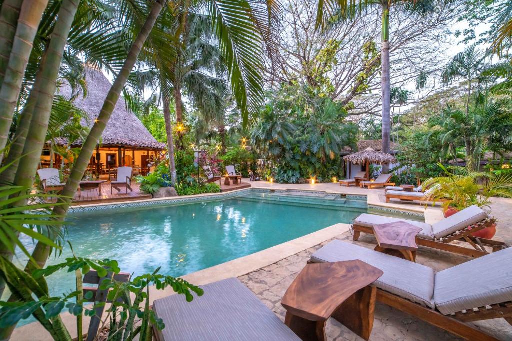 uma piscina num resort com palmeiras em Hotel Pasatiempo em Tamarindo