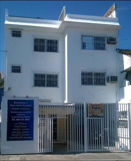 a white building with a gate in front of it at Hermoso departamento en Mazatlán in Mazatlán