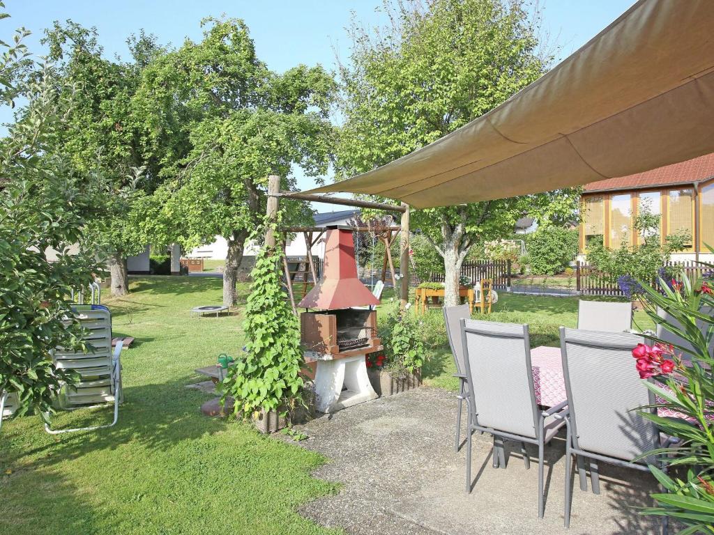 um pátio com cadeiras e um grelhador num quintal em Apartment with terrace and pool in the garden em Pracht