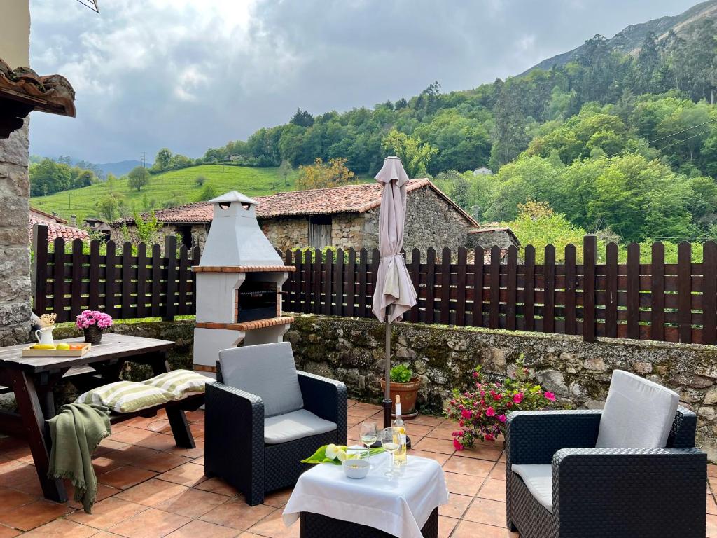 a patio with a table and chairs and an umbrella at La Nozaleda in Infiesto