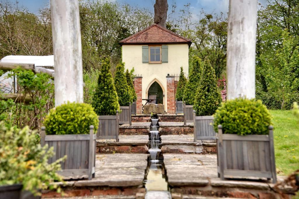 a garden with a small house in the background at The Folly in Hereford