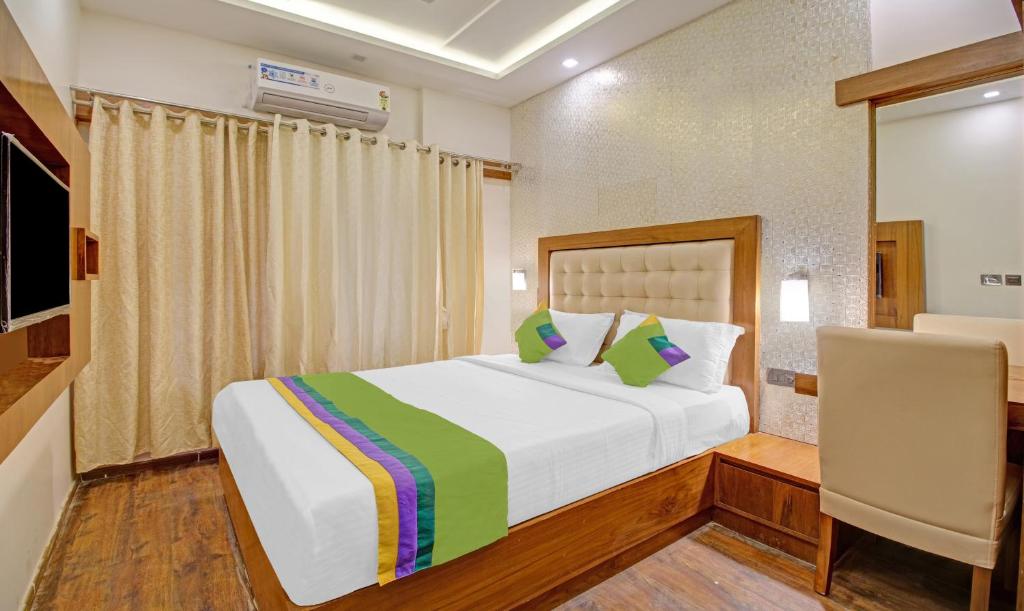 a bedroom with a bed and a chair in it at Treebo Trend White Inn in Bangalore