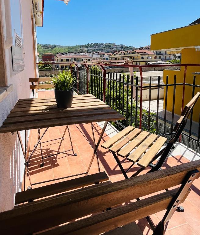 a wooden table and a chair on a balcony at Oltremare rooms Agropoli in Agropoli