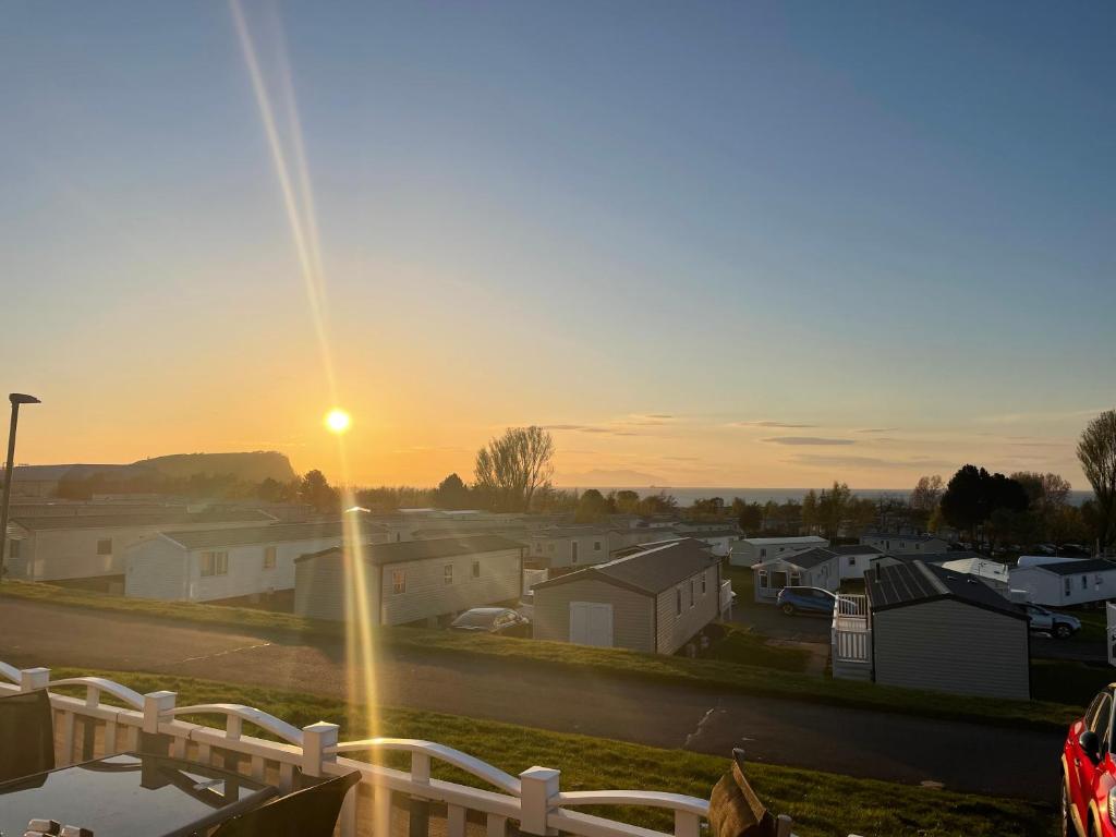 einen Sonnenuntergang vom Balkon einer Stadt in der Unterkunft JSNHolidays@CraigTara in Ayr