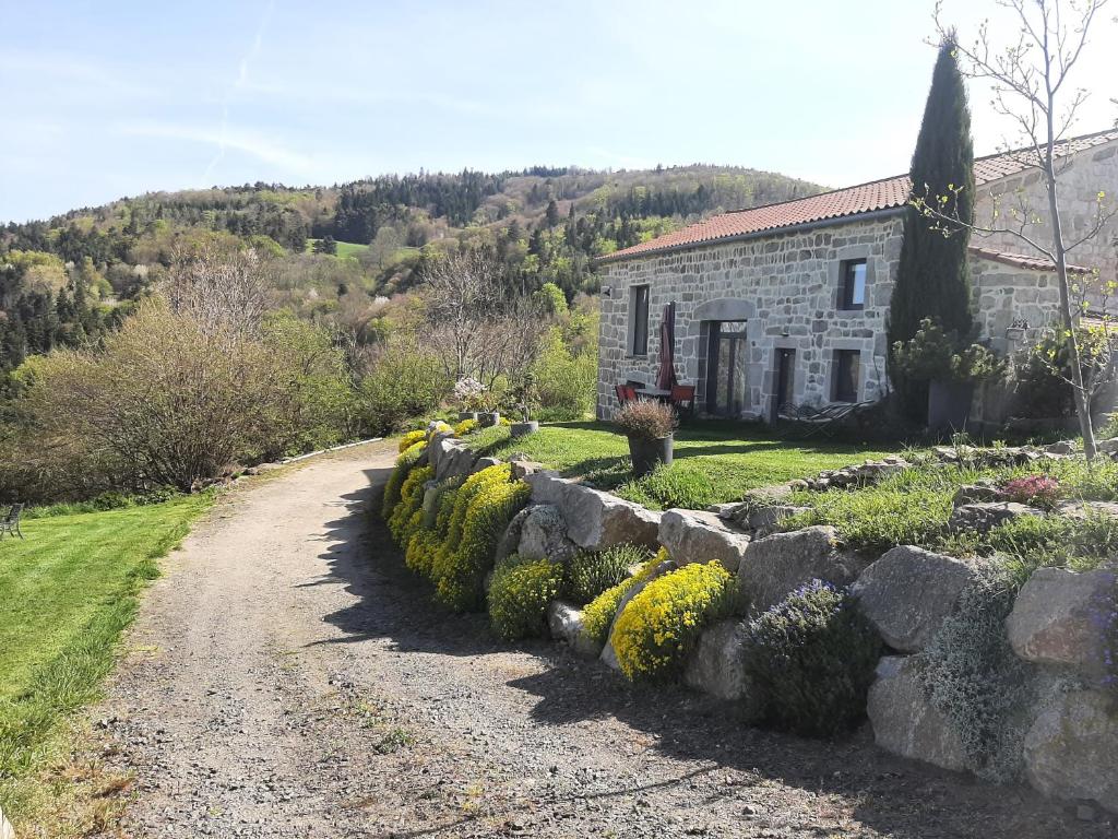 una casa de piedra con una pared de piedra junto a una carretera en Entre ruralité et modernité, en Roche