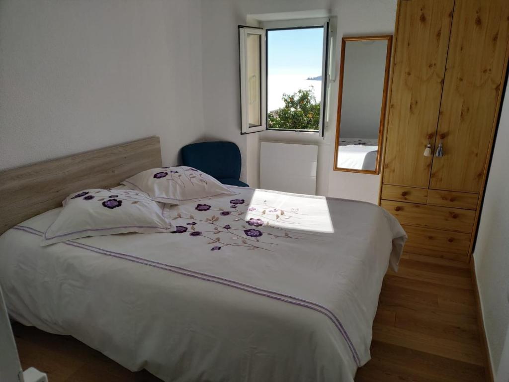 um quarto com uma cama branca com flores em Maison Trucchi em Menton