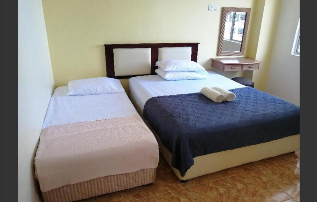 um quarto com 2 camas e um espelho em Apartment at Glory Beach Resort em Porto Dickson
