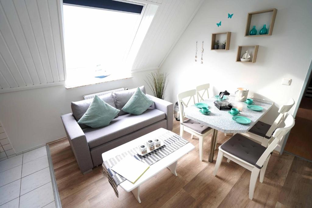 a living room with a couch and a table at Ferienwohnung Spiekeroog in Neuharlingersiel