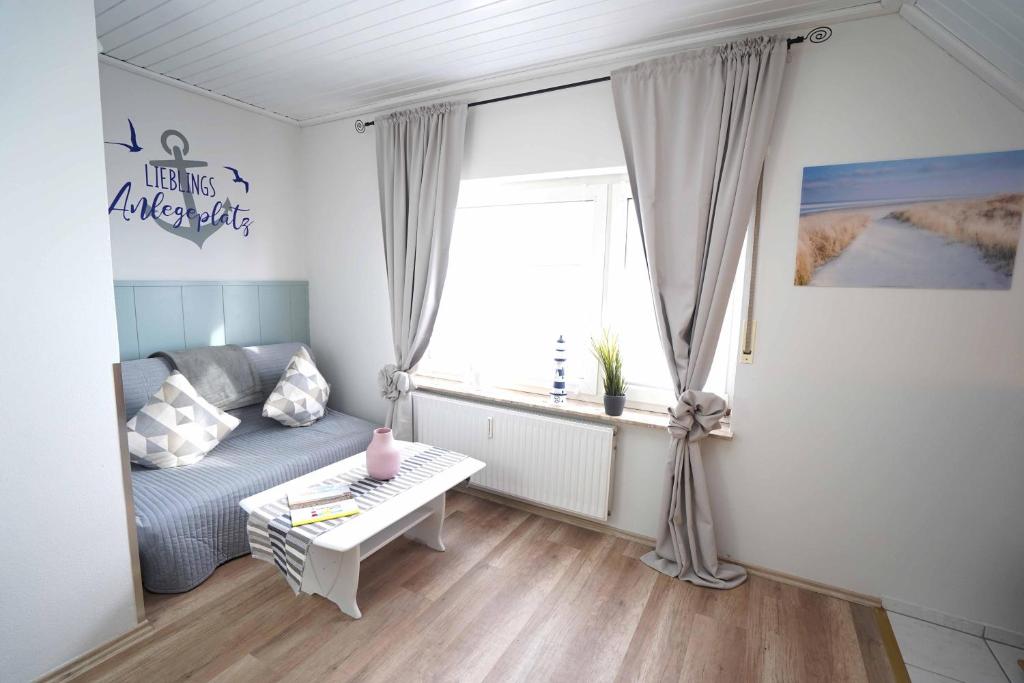 ein Wohnzimmer mit einer Couch und einem Fenster in der Unterkunft Ferienwohnung Langeoog in Neuharlingersiel