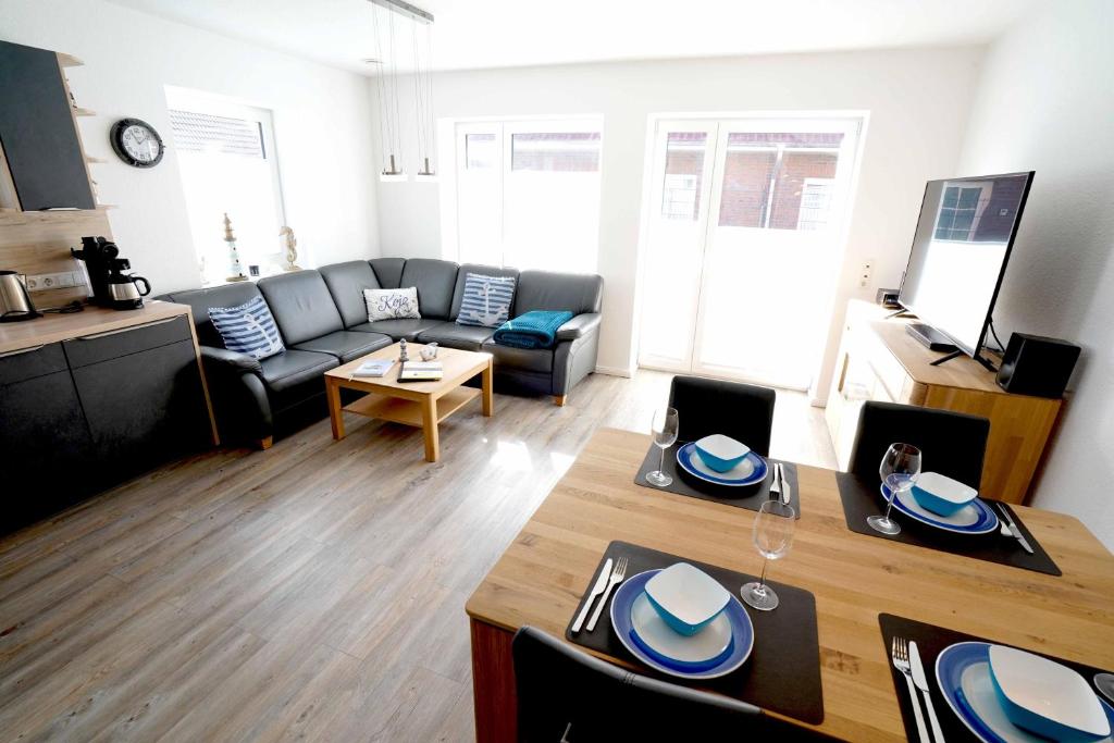 ein Wohnzimmer mit einem Sofa und einem Tisch in der Unterkunft Ferienhaus Lüttje Krabbe in Carolinensiel