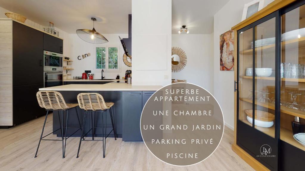 une cuisine avec un comptoir et des tabourets dans une pièce dans l'établissement Appartement T2 : Jardin, Piscine, Parking à Sainte-Maxime, à Sainte-Maxime