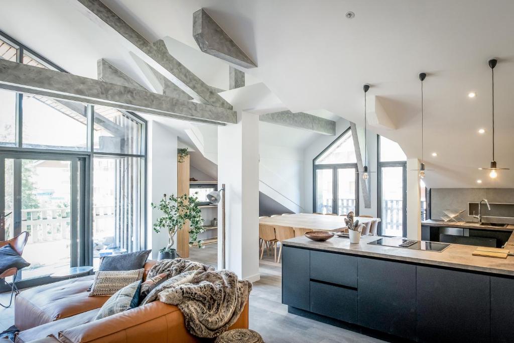 a living room with a couch and a kitchen at Chalets Patchwork in Valloire