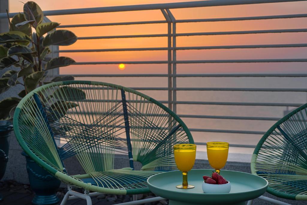 two glasses of beer on a table on a patio at Savoy Sea Side Hotel in Tel Aviv