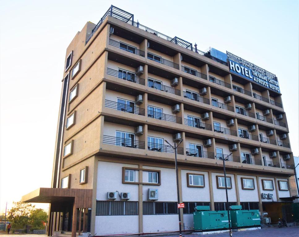 奇陶尔加尔Hotel The Grand Chittor, Chittorgarh的街道拐角处的酒店大楼