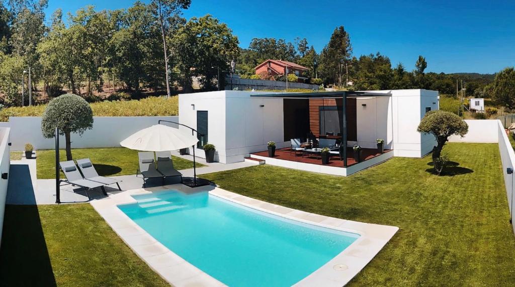 un patio trasero con piscina y una casa en Chalet Mia Sear Areas en Sanxenxo