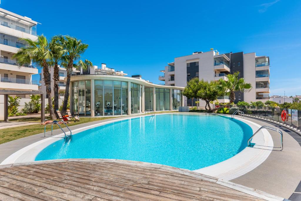 a swimming pool in front of a building at La Zenia Cocoon - Luxury Penthouse with jacuzzi, 2 pools, indoor heated pool, sauna, gym, playstation in Orihuela Costa
