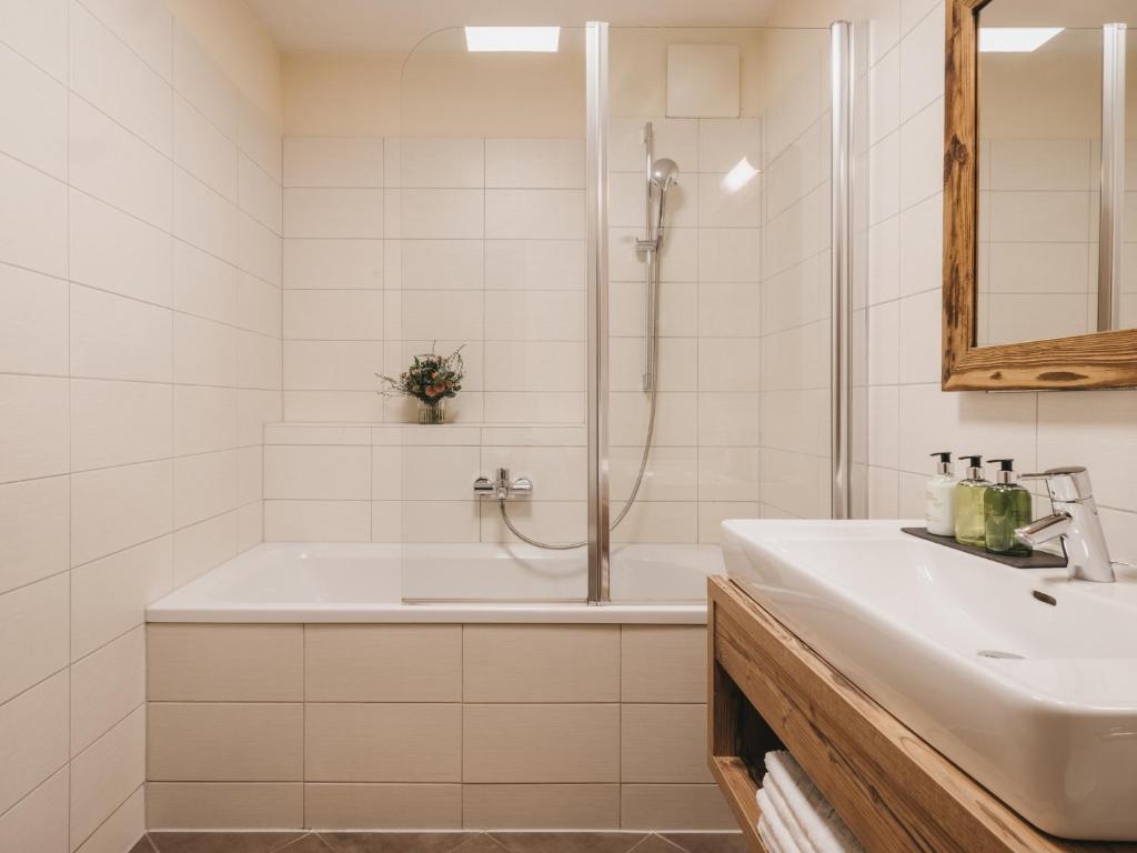 a white bathroom with a tub and a sink at VAYA Kaprun inklusive Zell am See Kaprun Sommer Karte in Kaprun