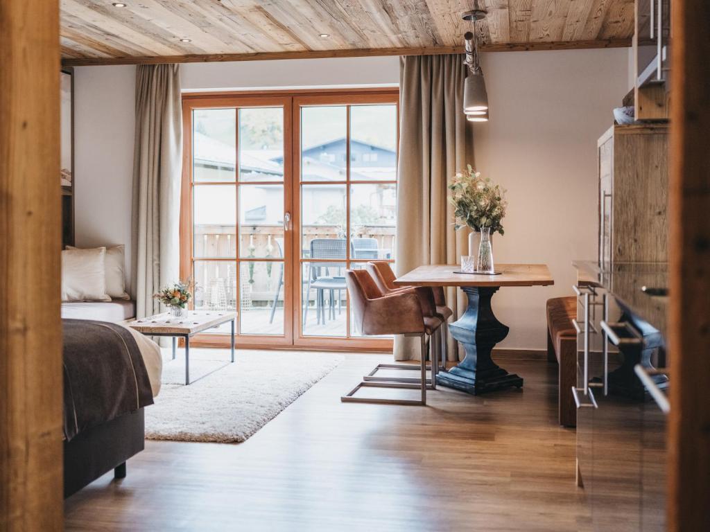 a bedroom with a bed and a table and a window at VAYA Kaprun inklusive Zell am See Kaprun Sommer Karte in Kaprun