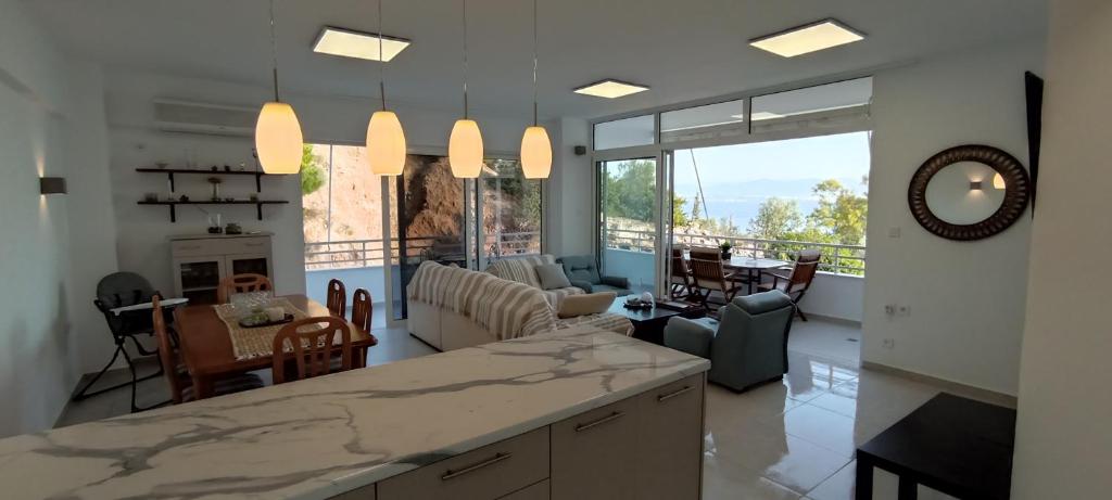 a large kitchen and living room with a large window at Atlas By Sea Apartment in Loutraki