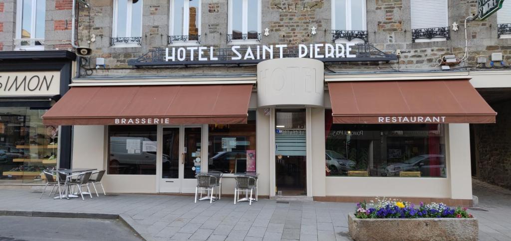 a restaurant with tables and chairs on a city street at Hôtel Saint - Pierre in Villedieu-les-Poëles