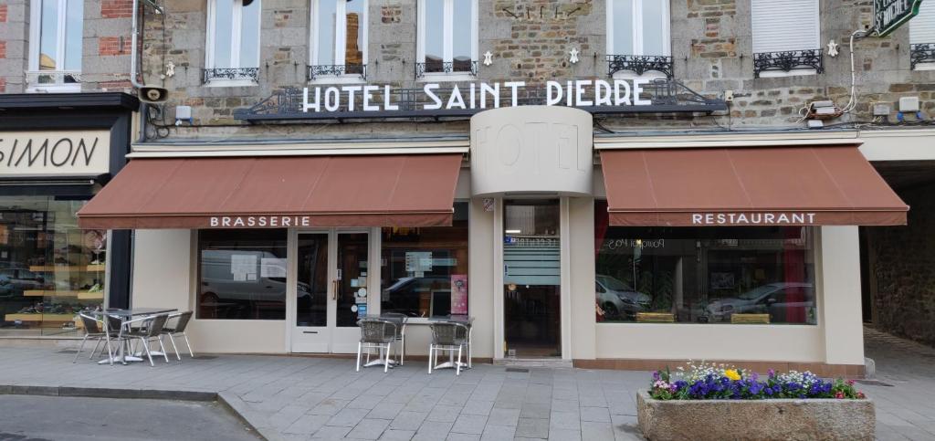 a restaurant with tables and chairs on a city street at Hôtel Saint - Pierre in Villedieu-les-Poêles