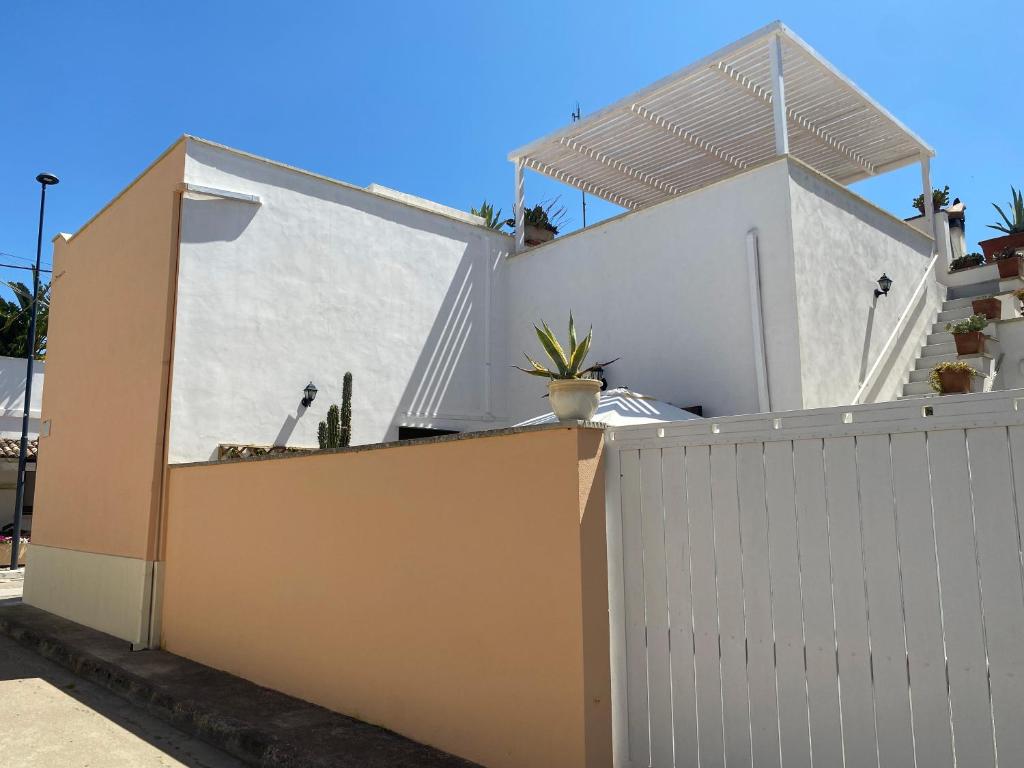 a house with a white fence and a gate at Casa Rosario - Villetta Indipendente in Felline