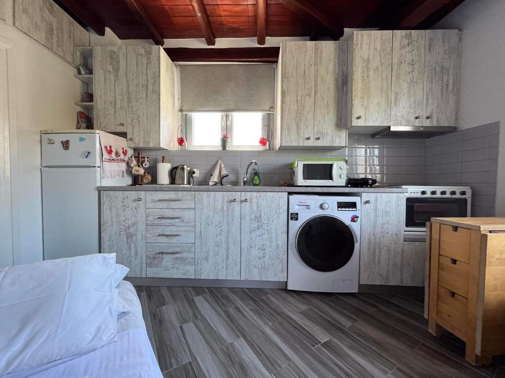 a kitchen with a white refrigerator and a dishwasher at Mykonian beauty(beach spot) in Platis Yialos Mykonos