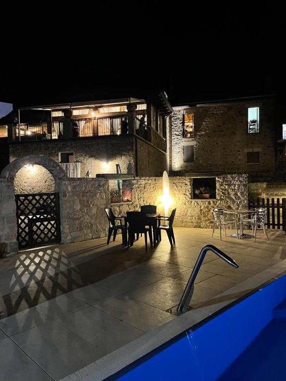 un patio extérieur avec une table et des chaises la nuit dans l'établissement Agriturismo La Dimora dei Cavalieri, à Vaglio di Basilicata