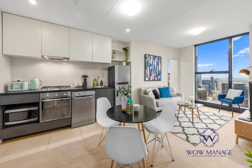 cocina y sala de estar con mesa y sillas en WOW Apartment on Collins en Melbourne