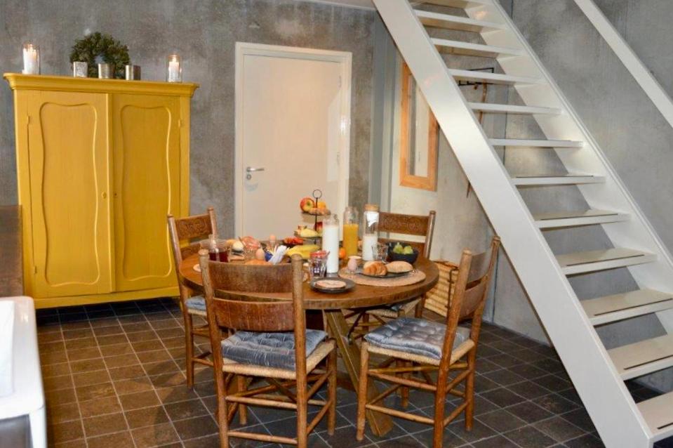 uma sala de jantar com uma mesa e cadeiras e uma escadaria em Vakantiewoning Kalverliefde em Zeerijp