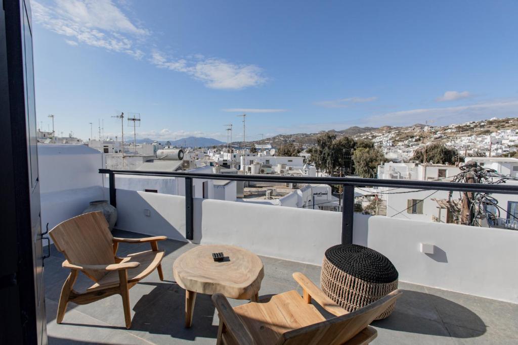 a balcony with chairs and a table and a view at She Mykonos - Luxury Apartments in Mikonos