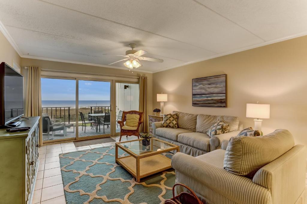 a living room with a couch and a table at Short Walk to the Beach Condo in Fernandina Beach