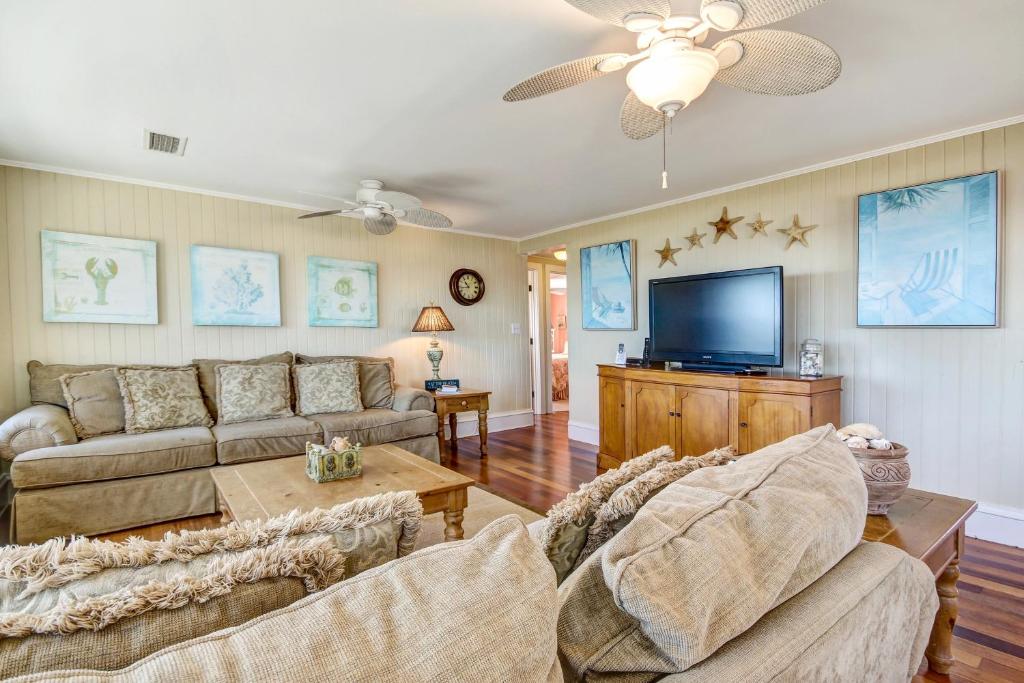 a living room with a couch and a flat screen tv at Rustic Oceanfront Cottage in Fernandina Beach