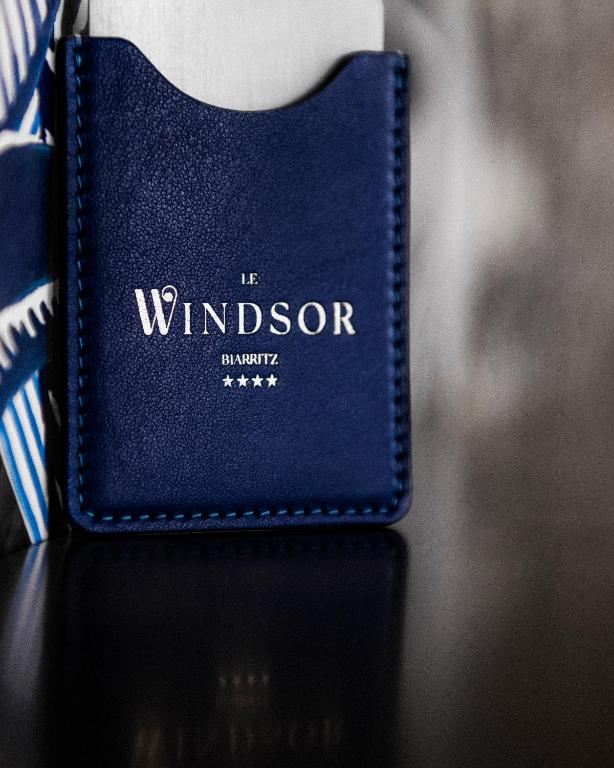 a blue book sitting on a table with a tie at Hôtel Le Windsor Biarritz in Biarritz