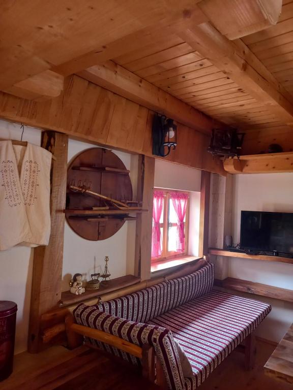 eine Bank in einem Zimmer mit Holzdecke in der Unterkunft Seoska kuca Vidikovac in Prozor