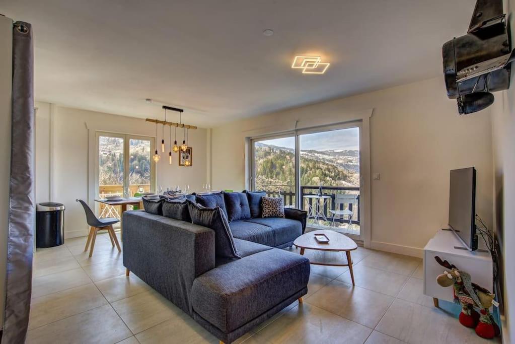 un salon avec un canapé bleu et une télévision dans l'établissement Apt. Marmottes -Fabulous 3 bed, 2 bath, sleeps 6, à Saint-Gervais-les-Bains