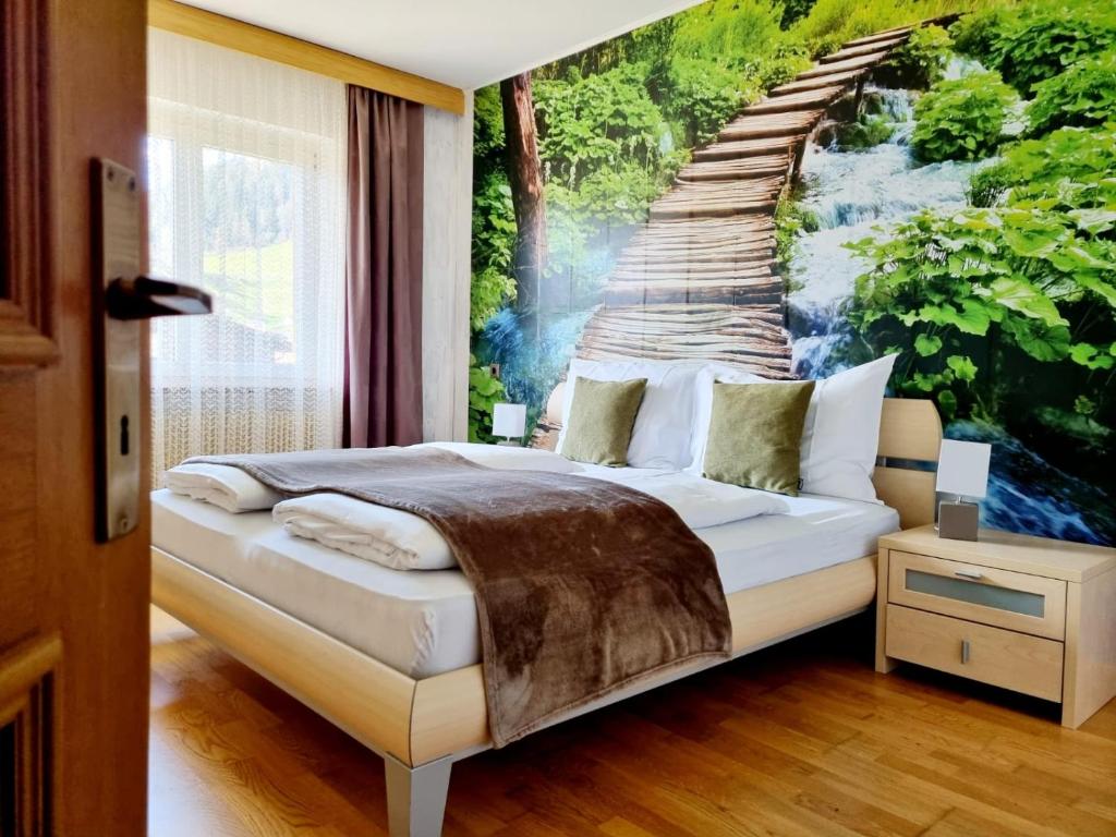 een bed in een kamer met een schilderij aan de muur bij Apartment Burger in Dobbiaco