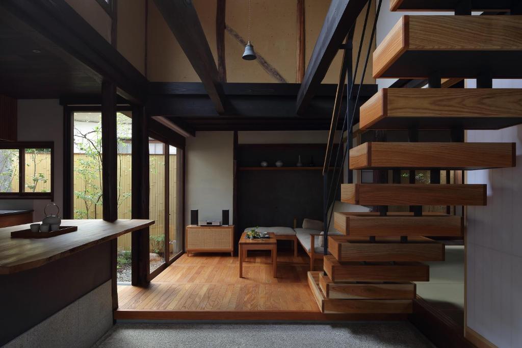 um quarto com uma escada em espiral numa casa em 滔々 御崎 町家の宿 toutou Onzaki Machiya no Yado em Kurashiki