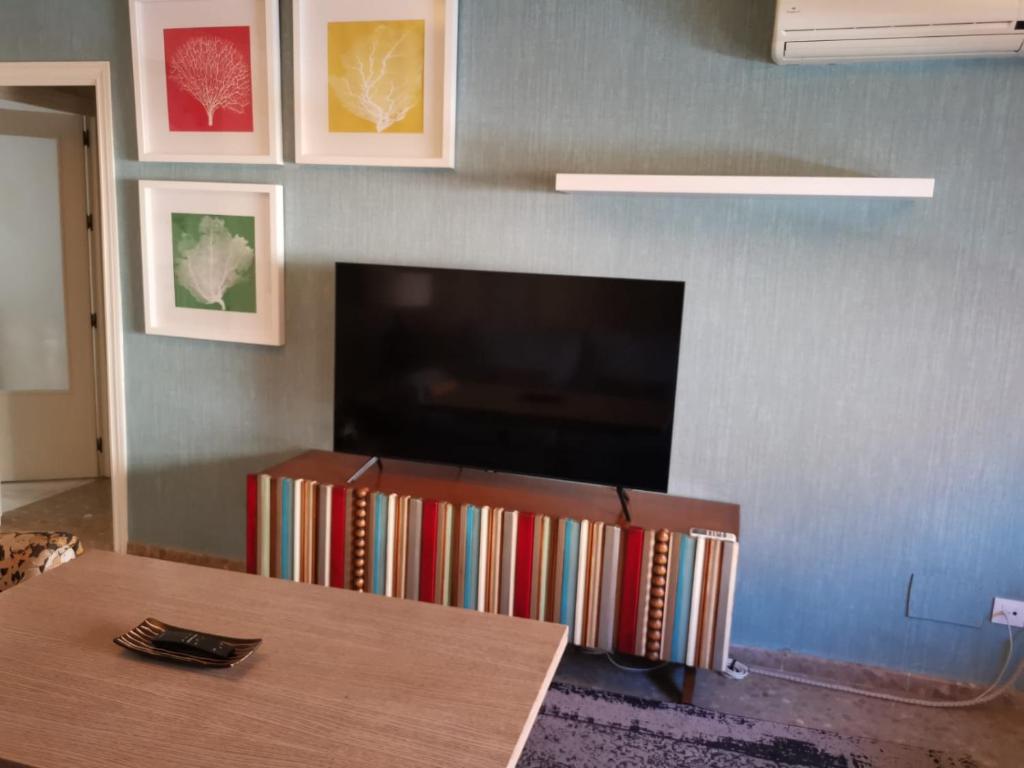a living room with a table and a flat screen tv at MRZ RENTALS JEREZ in Jerez de la Frontera