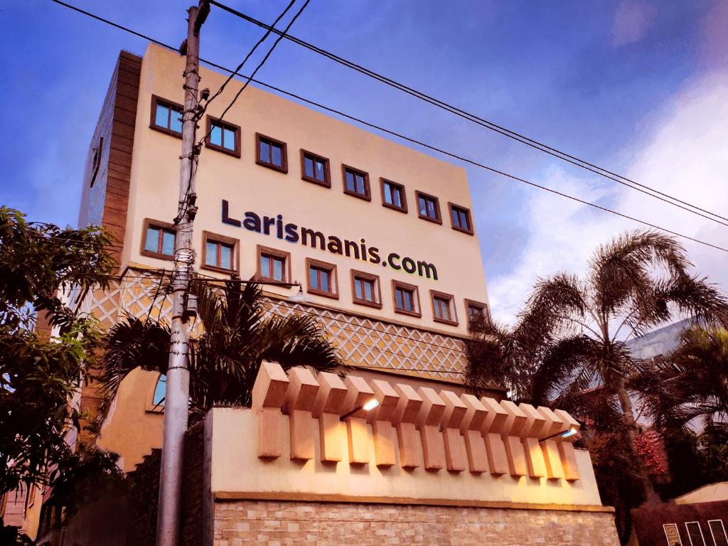 een groot gebouw met een bord aan de zijkant bij Hotel Syariah Larismanis in Semarang