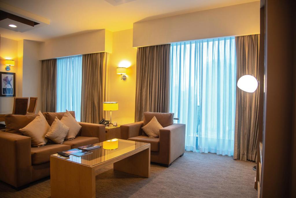 a living room with a couch and chairs and a table at Riu Plaza Panamá in Panama City